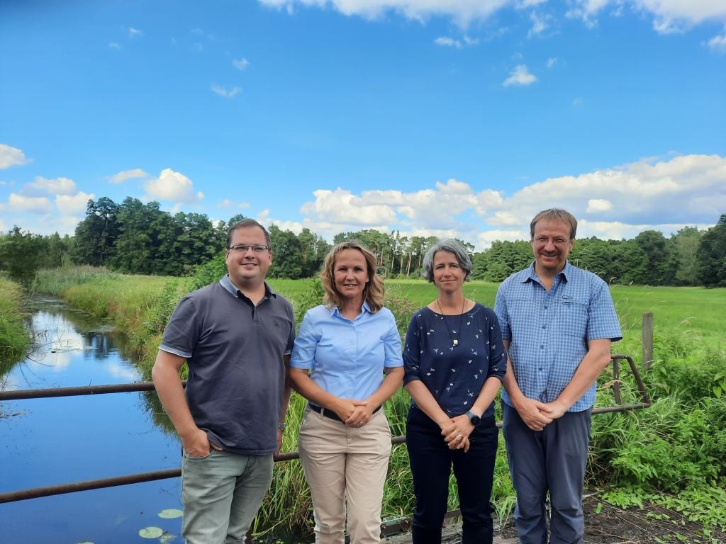 Das Bild zeigt Bundesumweltministerin Steffi Lemke zusammen mit drei Projektmitarbeiterinnen und Mitarbeitern des Landesamtes für Umwelt Brandenburg in den Möllmer Seewiesen. 