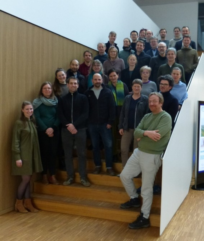 Viele Menschen stehen auf einer Treppe und lachen in die Kamera.